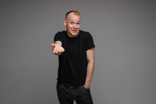 picture of handsome caucasian male keeping hands in the pockets isolated over the grey background
