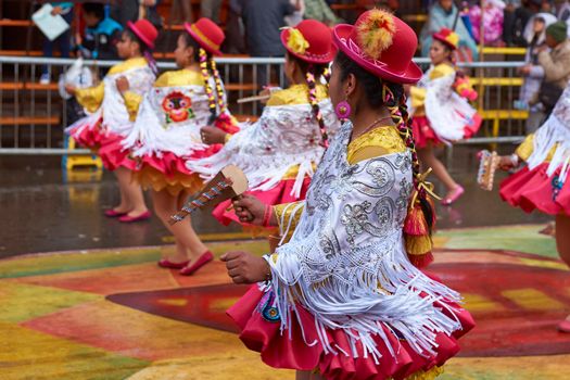 ORURO, BOLIVIA - FEBRUARY 25, 2017: Female Morenada dancers in colourful costumes parading through the mining city of Oruro on the Altiplano of Bolivia during the annual Oruro Carnival.