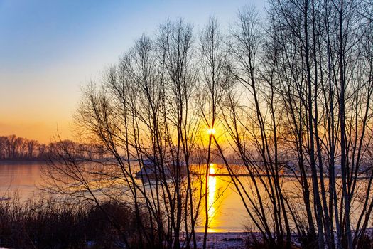 Frozen river and bright sun on horizon