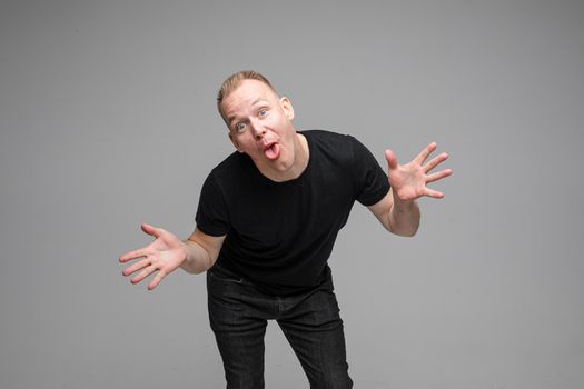 picture of happy man fooling and making faces on a camera isolated on grey background