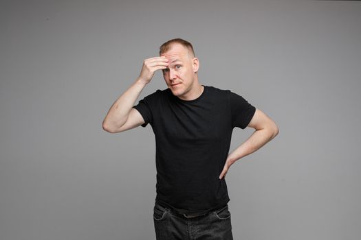 picture of caucasian male wearing a t-shirt and jeans isolated over the grey background