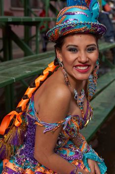 ORURO, BOLIVIA - FEBRUARY 25, 2017: Female Morenada dancers in colourful costumes parading through the mining city of Oruro on the Altiplano of Bolivia during the annual Oruro Carnival.