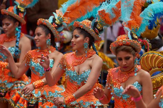 ORURO, BOLIVIA - FEBRUARY 25, 2017: Female Morenada dancers in colourful costumes parading through the mining city of Oruro on the Altiplano of Bolivia during the annual Oruro Carnival.