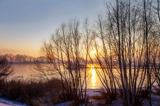 Frozen river and bright sun on horizon