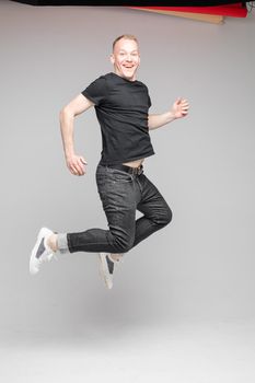 cheerful cacuasian male rejoices in studio on white background, backstage of a photosession