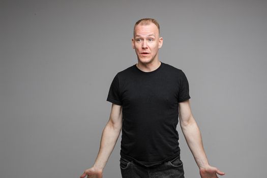 picture of caucasian male wearing a t-shirt and jeans isolated over the grey background