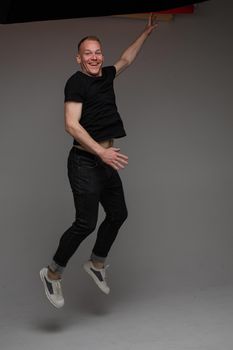 cheerful cacuasian male rejoices in studio on white background, backstage of a photosession