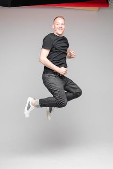 cheerful cacuasian male rejoices in studio on white background, backstage of a photosession