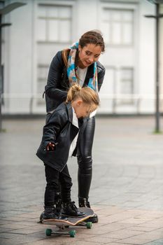 child and mom ride a skateboard