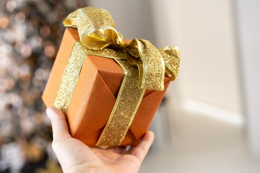 Christmas present gift box stacked close up. Holiday sale concept. Many gift box black, white, orange color with gold ribbon and light garland