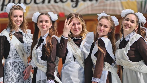 Smiling female graduates pose on the last day of school life