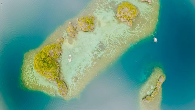 Aerial view of small islands Siete Pecados with boats in Coron Bay. Palawan