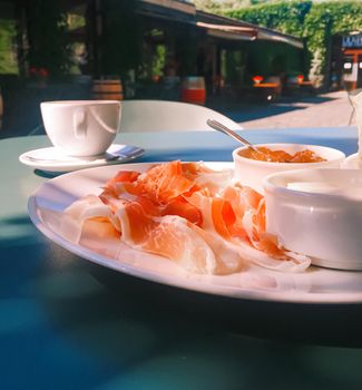 Breakfast outdoors in summer, ham, jam, butter and ham.