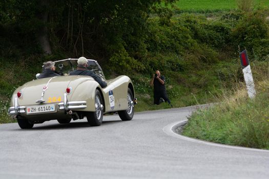 CAGLI , ITALY - OTT 24 - 2020 : JAGUAR XK 140 OTS SE 1954 on an old racing car in rally Mille Miglia 2020 the famous italian historical race (1927-1957