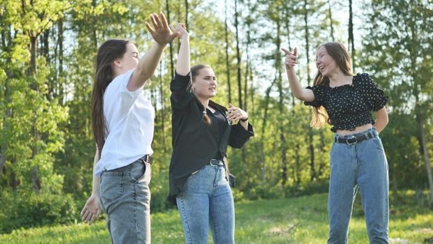 Joyful girls are dancing on a picnic near the forest