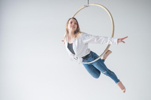 Caucasian woman in casual clothes and high heels shoes on air hoop