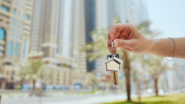 Hand girl holds the keys. The concept of buying an apartment or car in Dubai. Hand close-up