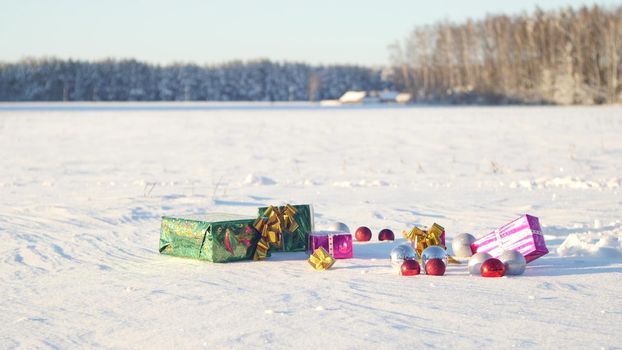 Christmas gifts in a field on snow in a sunny, frosty and clear weather outdoors