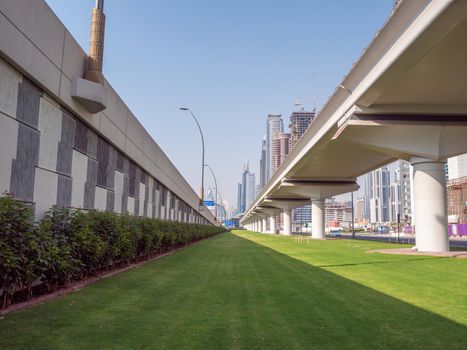 A green flowerbed with grass next to the road on Dubai Street