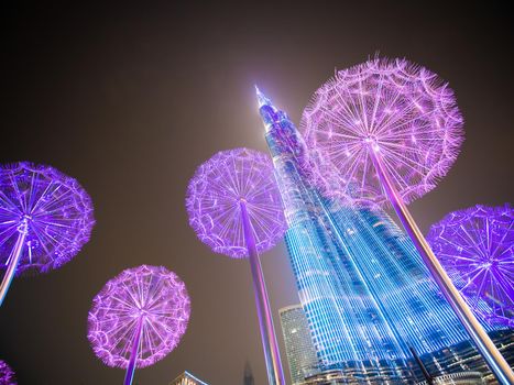 Burj Khalifa in the late evening against the background of luminous dandelions.