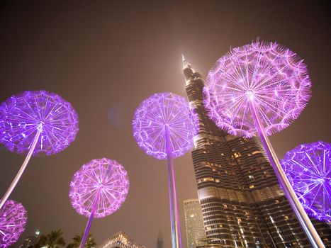 Burj Khalifa in the late evening against the background of luminous dandelions.