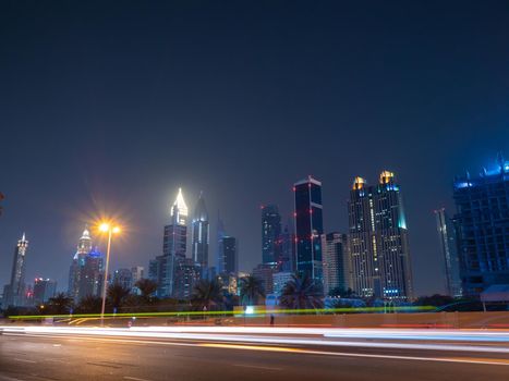 Dubai skyscrapers at night with road traffic late at night