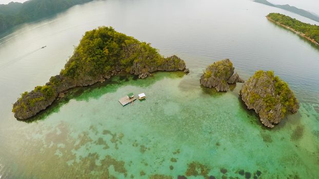 Aerial view of small islands Siete Pecados with boats in Coron Bay. Palawan