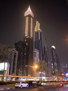 Dubai skyscrapers at night with road traffic late at night