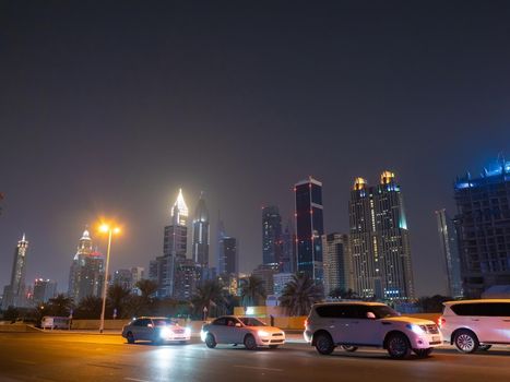 Dubai skyscrapers at night with road traffic late at night