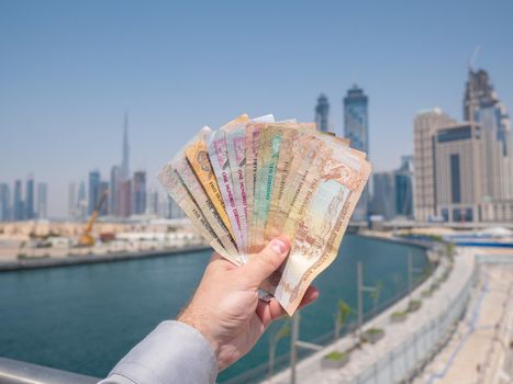 A man holds the money of the United Arab Emirates. Dirham