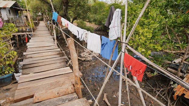 Houses of the poor in the Filipino slums. The swamp. Wooden bridges from planks on high water. Clothes on laces. Shooting in motion