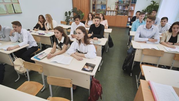 Students in the classroom are looking at the board during the lesson