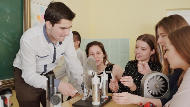 Students play with electroforming machine before the lesson of physics