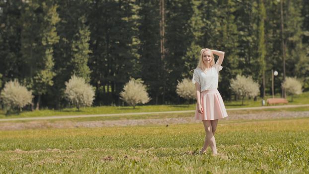 A happy young russian girl is running in the city park