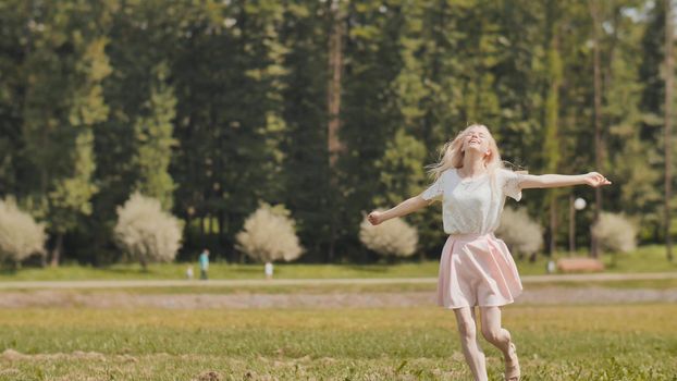 A happy young russian girl is running in the city park