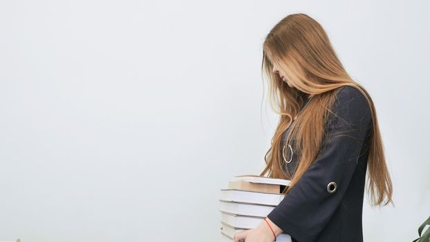 The schoolgirl tired is in a bad mood from heavy books