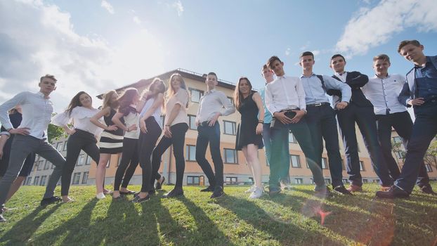 Posing of high school students against the background of his school. Russian schoolchildren. Shooting in motion