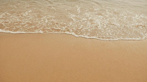 Soft wave of the sea on the sandy beach.