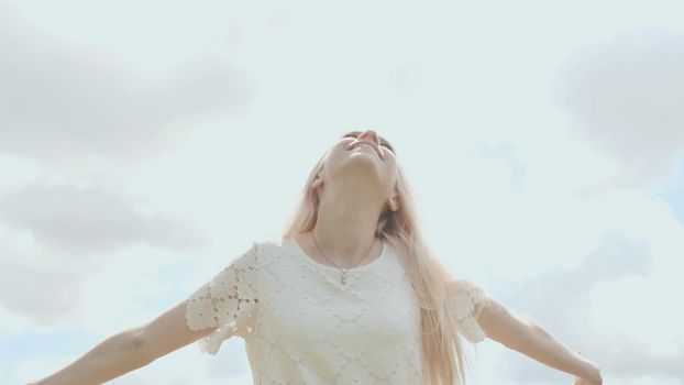 Young Russian girl blonde posing against a white sky on a summer day