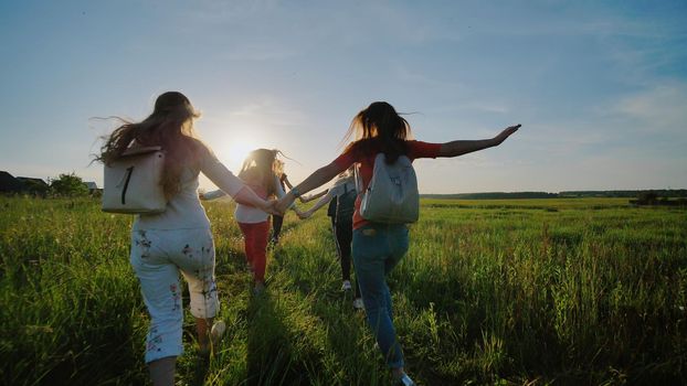 Happy senior pupils flee and toss their portfolios against the sunset. Happy ending school days