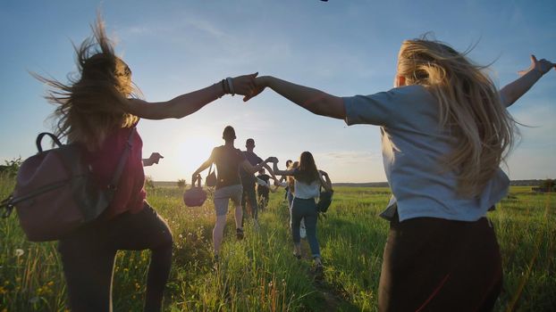 Happy senior pupils flee and toss their portfolios against the sunset. Happy ending school days. Slow motion