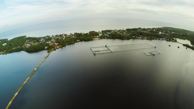 Filipino village with a lake. Anda. Bohol Island. Evening time. Aerial view. Fine artificial road