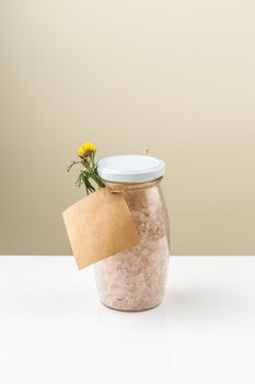 Glass jar with bath salt with empty label on it. Sea salts for relaxation and treatment