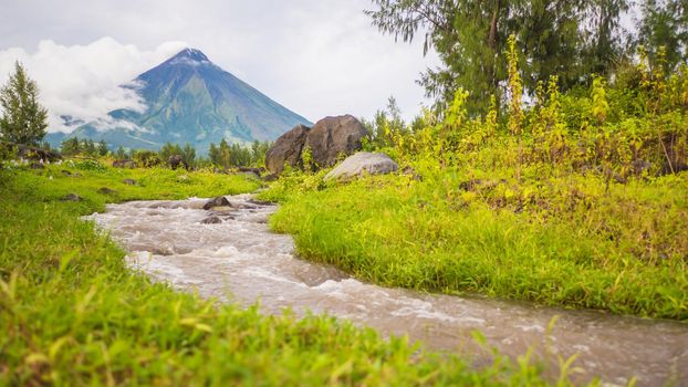 River near Mayon Volcano is an active stratovolcano in the province of Albay in Bicol Region, on the island of Luzon in the Philippines. Renowned as the perfect cone because of its symmetric conical shape