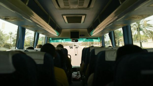 Inside the tourist bus with passengers. Travel to Abu Dhabi