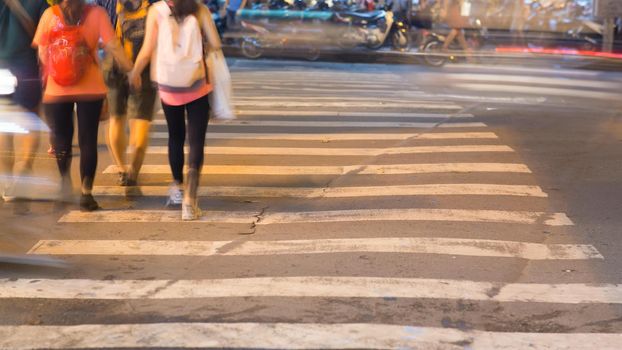 Blurred motion of cars and people on the pedestrian pedestrian passage. Vietnam.