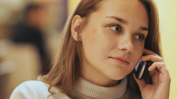 Cute young girl talking on a cell phone. Close-up