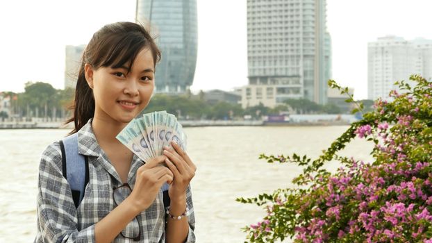 Vietnamese girl photographer takes pictures of nature in the city center at sunset.