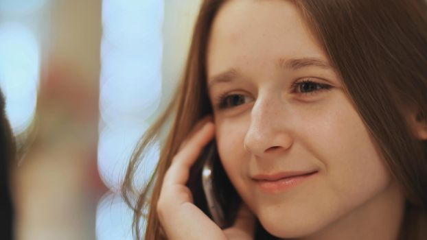 Cute young girl talking on a cell phone. Close-up
