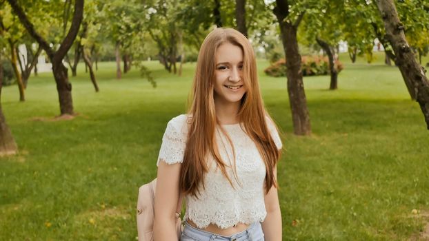 Follow me girl concept. Young pretty happy student model smiling and walking in park